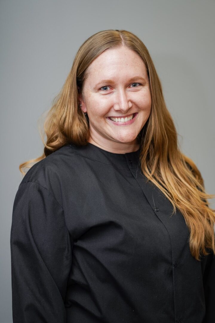 A woman in black shirt smiling for the camera.