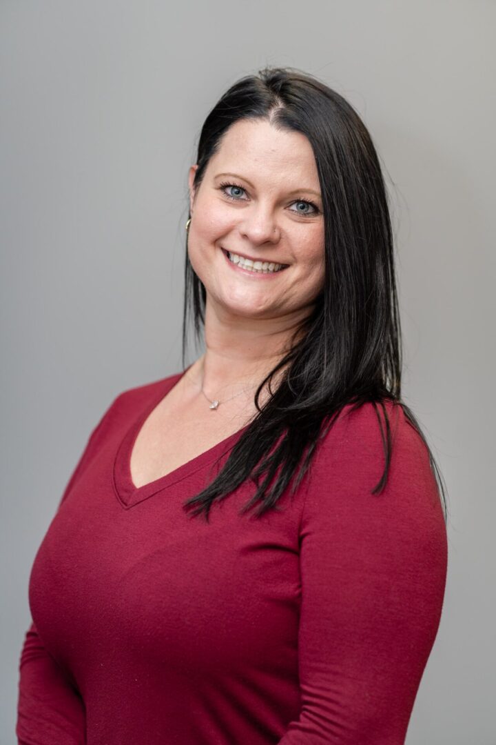 A woman in red shirt smiling for the camera.