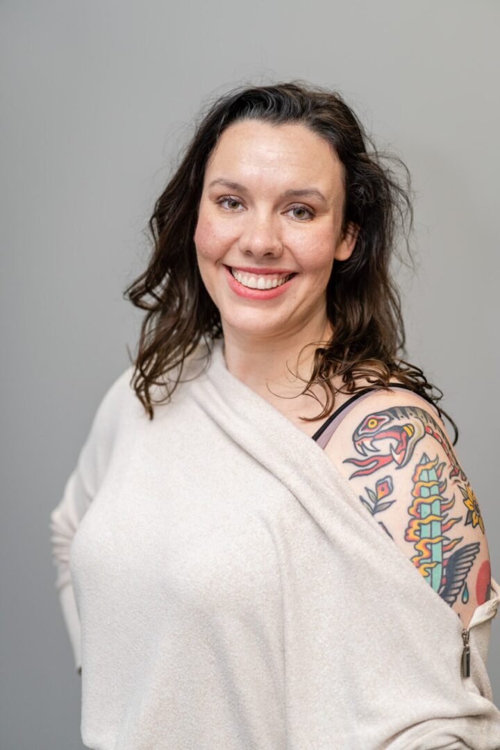 A woman with tattoos on her arm and shoulder.