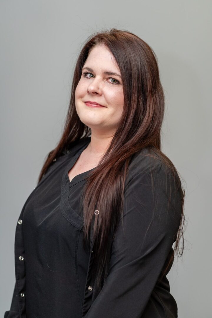 A woman with long brown hair wearing black.