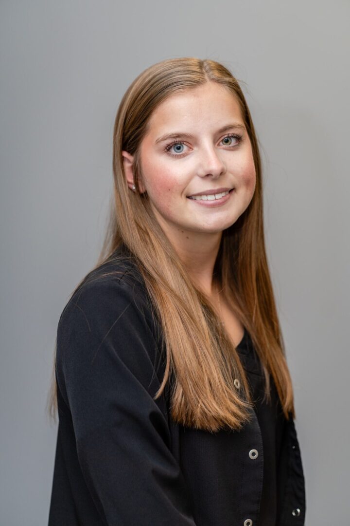 A young woman with long hair and wearing black.