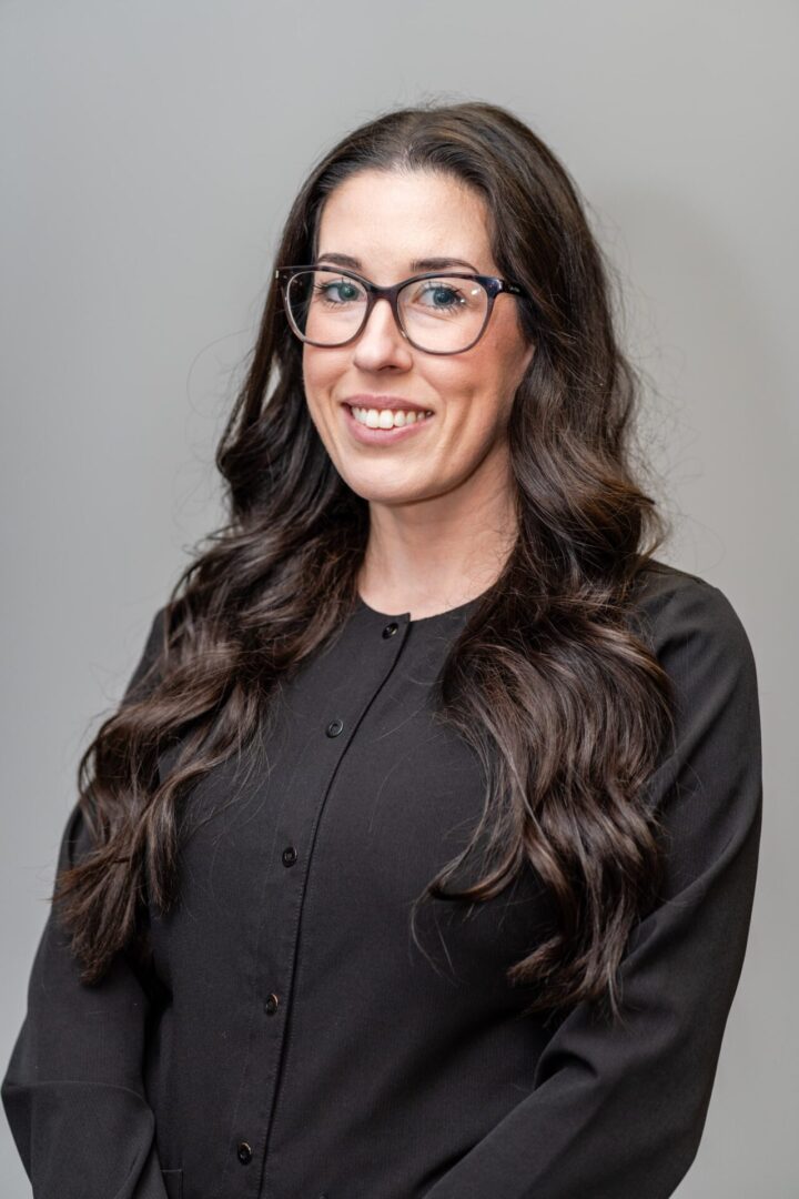 A woman with long hair wearing glasses and black shirt.