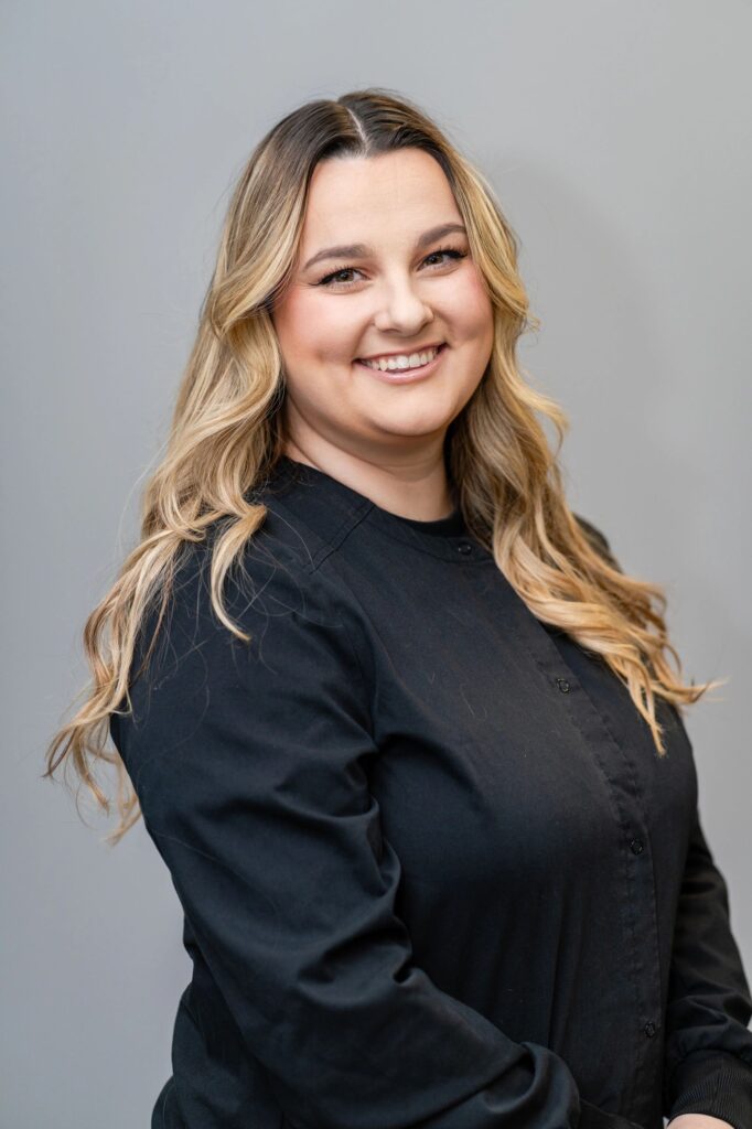 A woman in black shirt smiling for the camera.