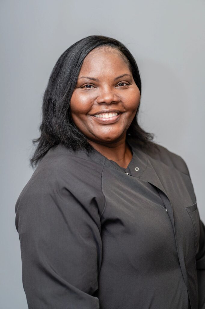 A woman in black shirt smiling for the camera.